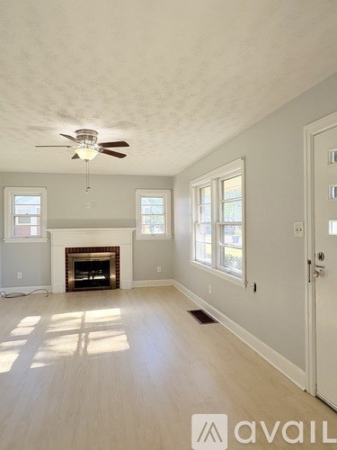 A room with a fireplace and a ceiling fan.