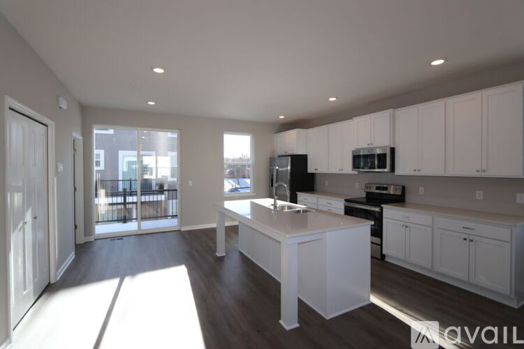 A kitchen with white cabinets and a large island.