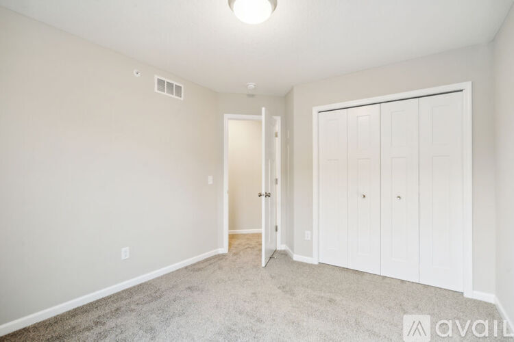 A bedroom with a carpeted floor and a white door.