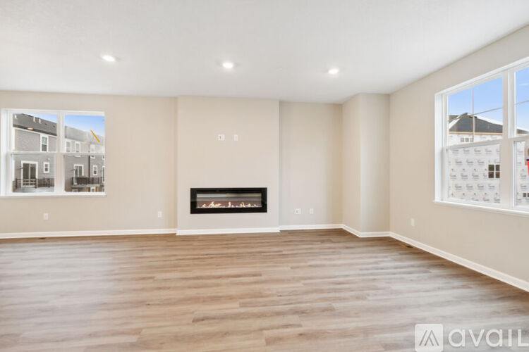 A spacious living room with a fireplace and large windows.