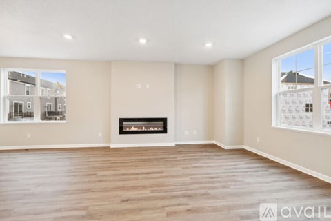 A spacious living room with a fireplace and large windows.