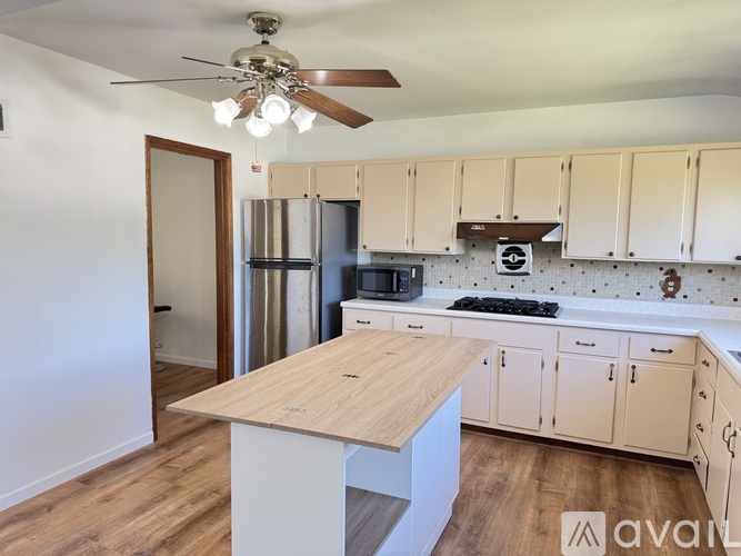 A kitchen with a wooden table and white cabinets.