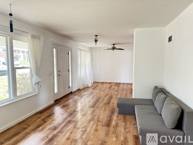 A living room with a grey couch and a wooden floor.