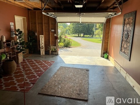 A hallway with a rug on the floor and a door with a sign that says "welcome".