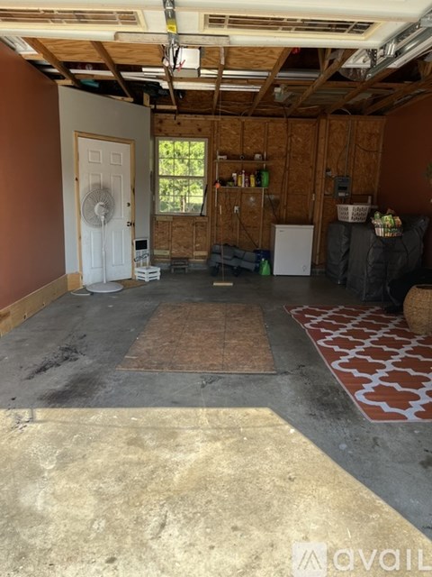 A room with a fan and a door is under construction.