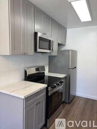 A kitchen with a refrigerator, oven, and microwave.