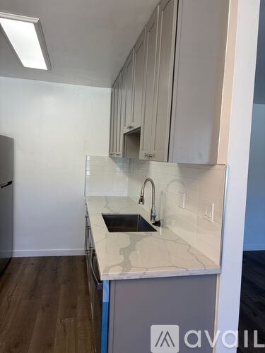 A kitchen with a sink and a refrigerator.