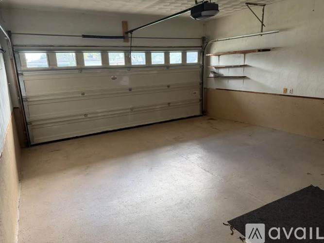 A spacious garage with a ceiling fan and a closed white garage door.