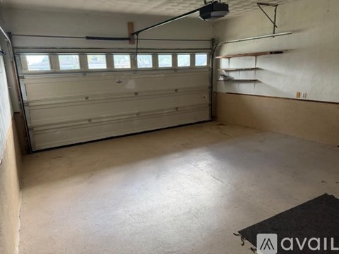 A spacious garage with a ceiling fan and a closed white garage door.