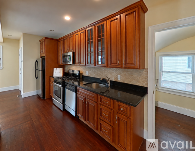 A kitchen with wooden cabinets and black countertops.