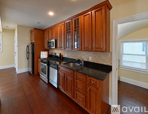 A kitchen with wooden cabinets and black countertops.