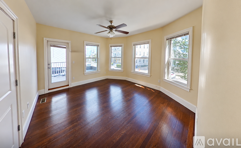 A room with wooden floors and a ceiling fan.