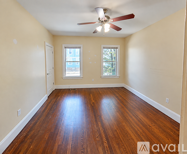 A room with wooden floors and a ceiling fan.