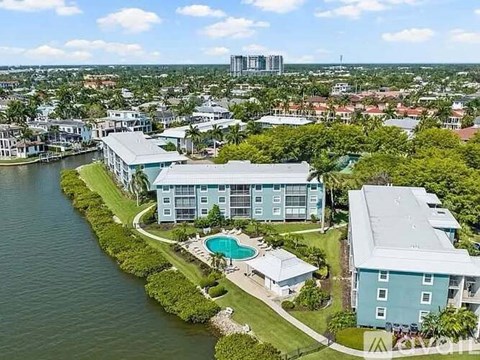 A large blue building with a pool in front of it.