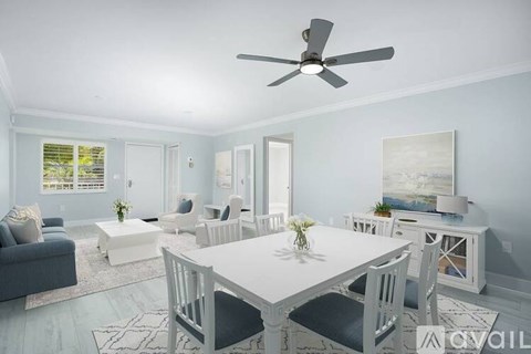 A dining room with a white table and chairs.