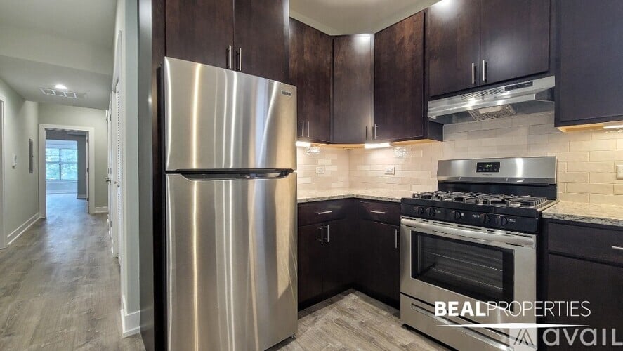 A modern kitchen with dark wood cabinets and stainless steel appliances.