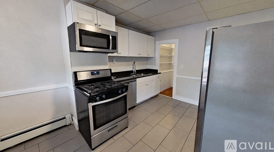A kitchen with a stainless steel refrigerator, microwave, and oven.