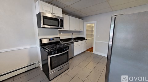 A kitchen with a stainless steel refrigerator, microwave, and oven.