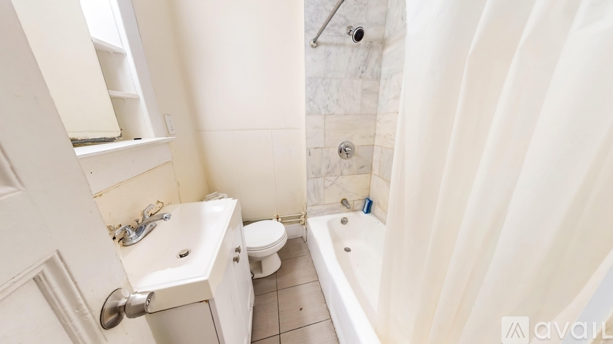 A white bathroom with a tub, toilet, and sink.