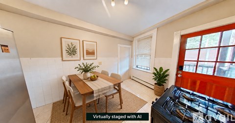 A dining room with a table set for two and a plant on the table.
