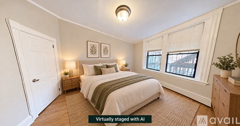 A bedroom with a bed, nightstands, and a window.