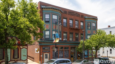 A building with a red brick facade and a green trim.