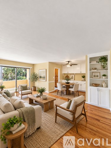 A living room with a couch, chairs, and a dining table.