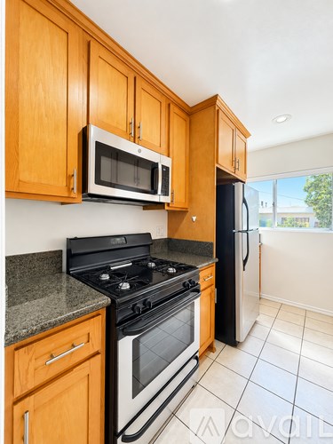 A kitchen with wooden cabinets and black appliances.