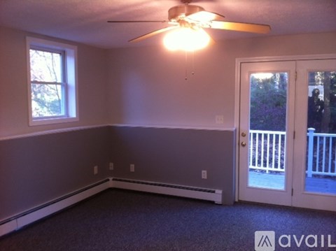 A room with a ceiling fan and a window.