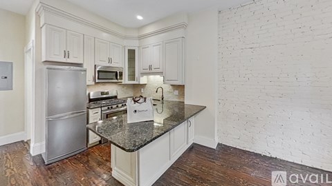 A kitchen with a granite countertop and stainless steel appliances.