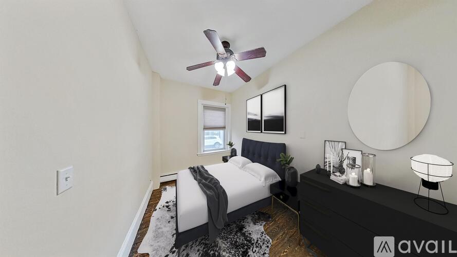 A bedroom with a bed, a dresser, and a ceiling fan.