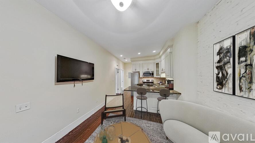 A living room with a television, a couch, and a dining table.