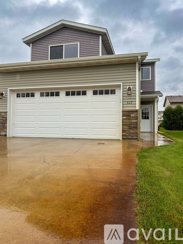 A house with a grey roof and a white garage door.