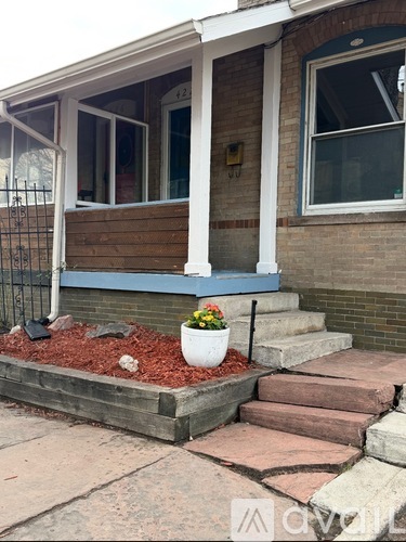 A house with a flower pot on the steps.