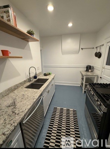 A kitchen with a checkered floor mat.