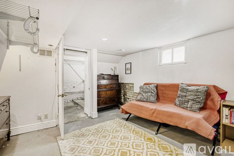 A living room with a couch and a rug.
