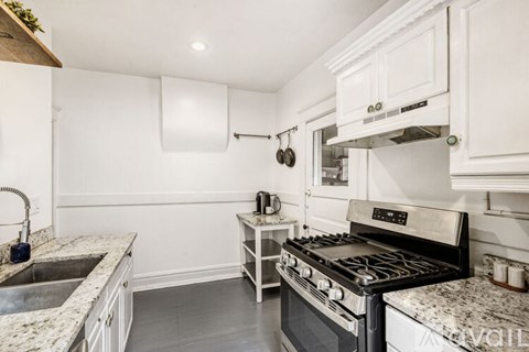 A modern kitchen with a stove top oven and a sink.