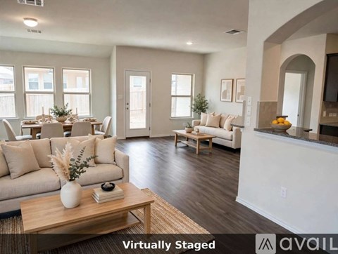 A living room with a couch, coffee table, and a dining table with chairs.