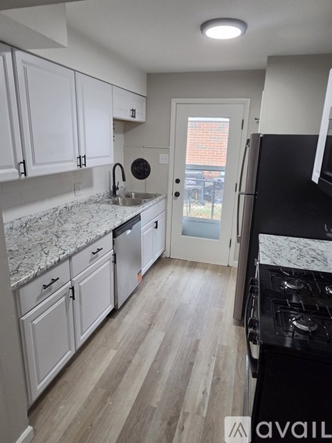 A kitchen with white cabinets and a black stove top oven.