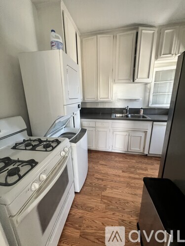 A kitchen with a white stove and white cabinets.