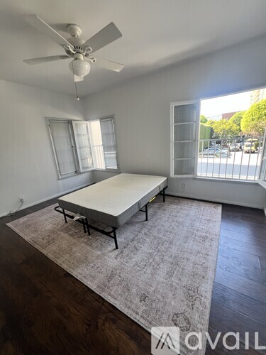 A bedroom with a bed, a ceiling fan, and a rug.