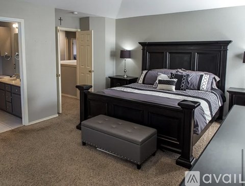 A bedroom with a large bed and a dressing area.