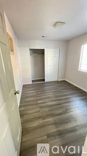 A room with a wooden floor and a white door.
