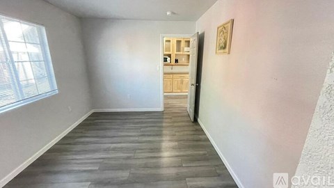 A room with a wooden door and a window with blinds.
