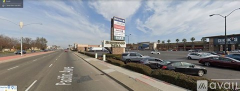 A street view with cars parked on the side and a building with a sign that reads "DICK'S".