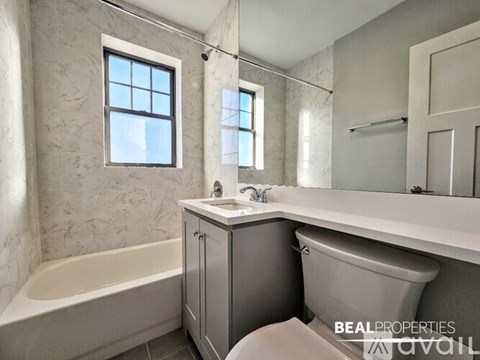 A bathroom with a tub, sink, and toilet.