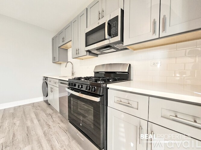 A modern kitchen with a stove top oven and microwave above it.