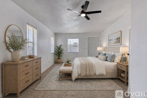 A bedroom with a large bed, a dresser, and a ceiling fan.
