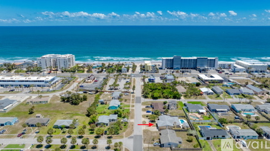 A bird's eye view of a coastal town with buildings, roads, and the ocean in the background.