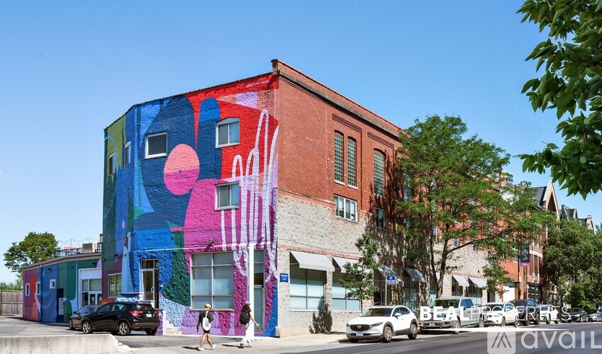 A woman walks past a colorful mural on a building.